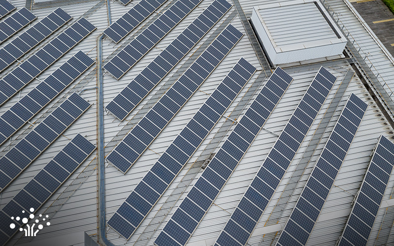 Aerial view of commercial rooftop solar panel installation on warehouse.