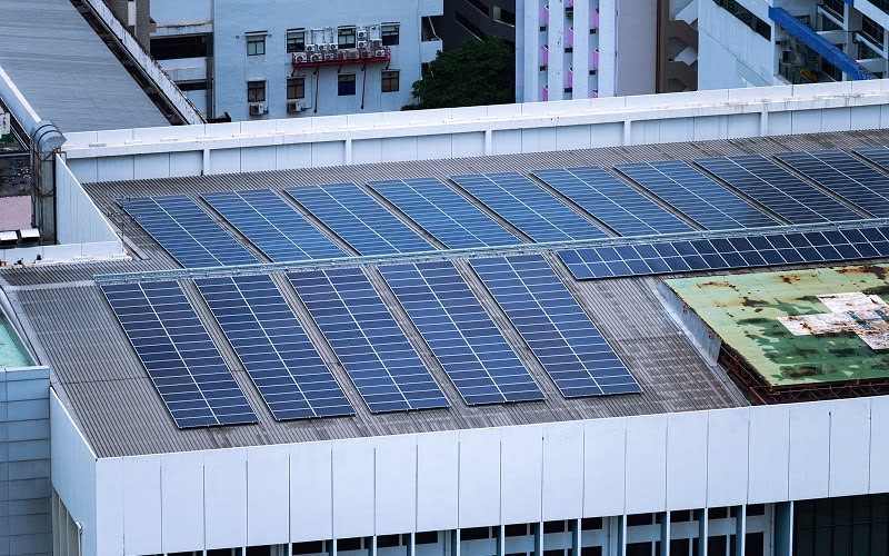 Commercial rooftop solar panel array installation on urban building.